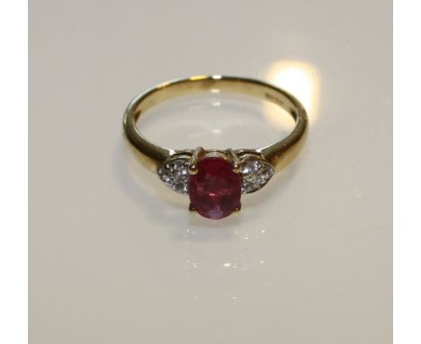 A 9ct yellow gold pink ruby ring with diamond shoulders.