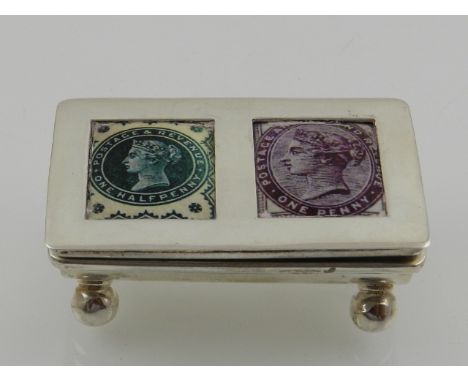 A novelty silver stamp box, the hinged lid set with two enamel plaques designed with stamps, the interior with two compartmen