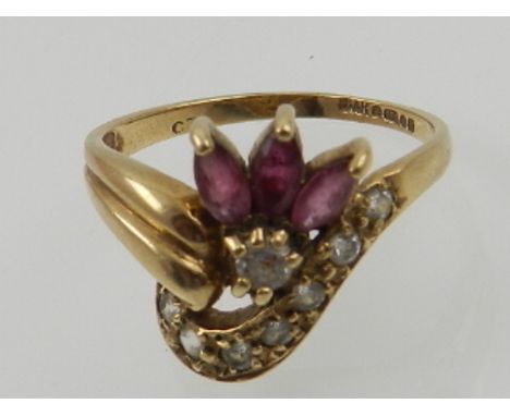 A 9 carat yellow gold, diamond, and ruby cluster ring, set three marquise cut rubies, and eight round cut diamonds. 