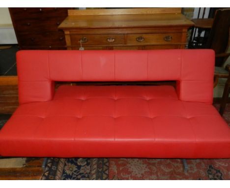 A Contemporary red leather metamorphicm sofa daybed, raised on a chrome base.