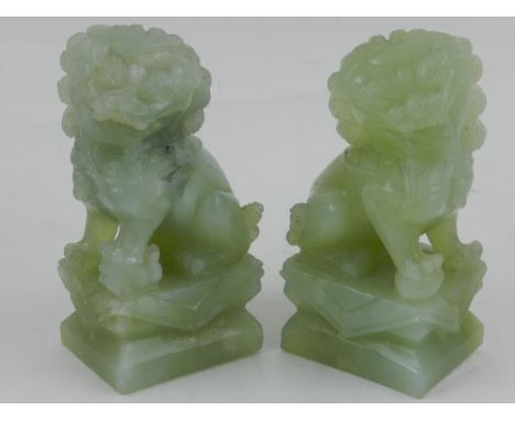 A pair of jade dogs of Fo, seated on plinths. H.12cm