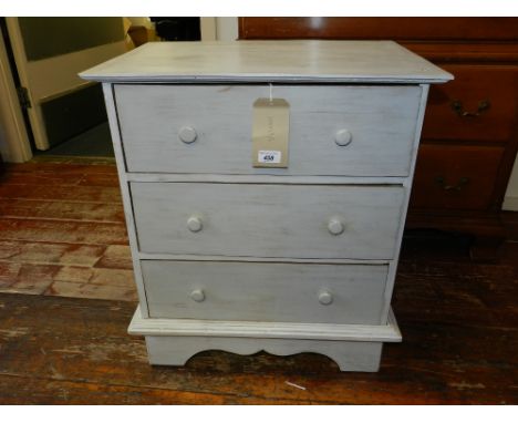 A Contemporary white painted and distressed chest of three long drawers, raised on a carved bracket base. H.68cm W.49cm D.42c