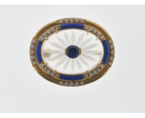 A vintage 18ct gold brooch set with an oval rock crystal panel with floral engraving set with an oval cut sapphire to the cen