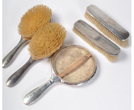 A 1920s Art Deco style silver hallmarked dressing table / vanity brush set consisting of two hairbrushes, a hand held mirror 