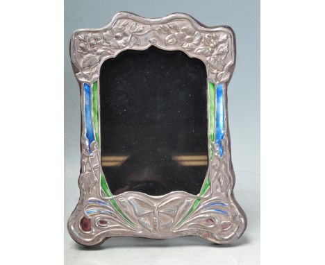 A stamped sterling silver and enamelled Art Nouveau style photo frame having flower motifs to the top and a central butterfly