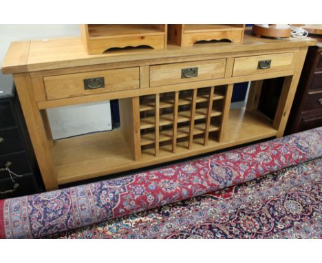 A contemporary light oak kitchen sideboard with bottle rack  CONDITION REPORT: 180cm long by 45cm deep by 83cm high