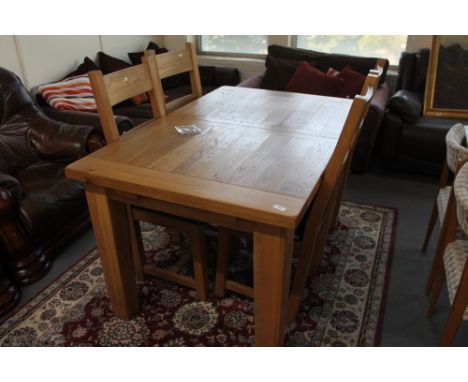 A light oak extending dining table and four ladder backed chairs 