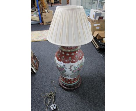 A Chinese table lamp on wooden stand 