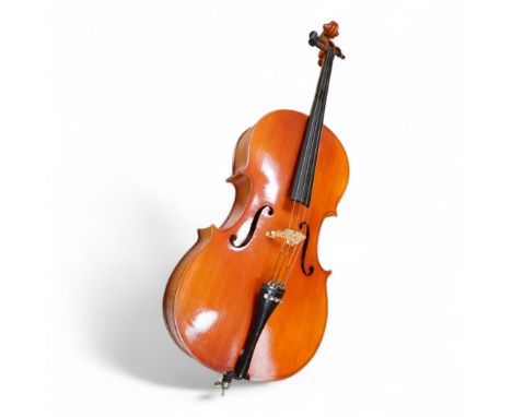 A modern student’s cello in a soft case and a student’s Spanish classical guitar