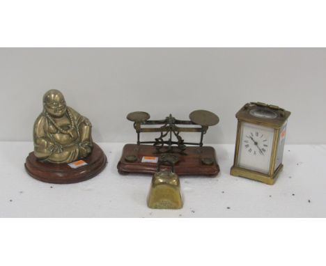 A small brass Carriage Clock, with white enamel dial; a brass model of a seated Buddha; a small brass and mahogany Postage Sc