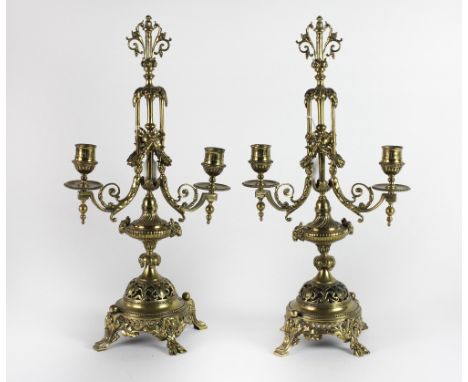 A pair of late 19th Century two branch brass Candelabra, in the Adams taste, decorated with garlands, foliage, rams head, on 