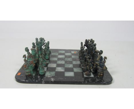 An unusual brass Chess Set, modelled as Ancient Roman Figures, on a chequered marble board. (1)