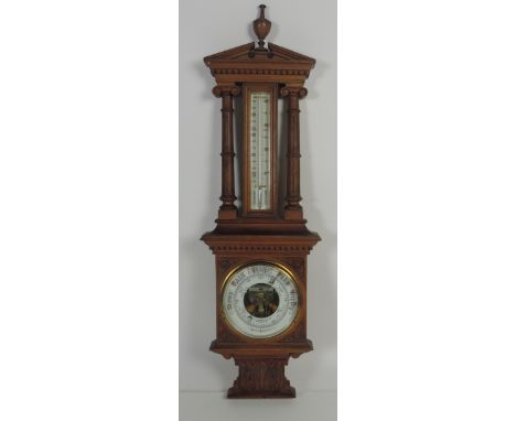 An unusual late Victorian carved oak Barometer / Thermometer, the broken pediment and dentil moulded cornice over large therm