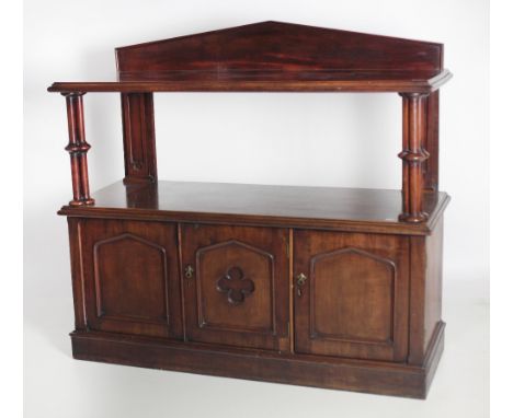 An unusual William IV Irish mahogany Dumbwaiter, in the Gothic taste, the arched back over one tier shelf, supported by clust