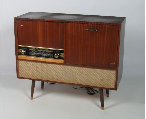 A "Two in One" H.M.V. Record and Radio Player, in a mahogany case on turned feet, approx. 90cms (35 1/2") wide. (1)