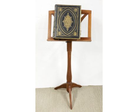 An adjustable light wood tripod lectern together with a leather bound Holy Bible, H. 105cm x W. 46cm.