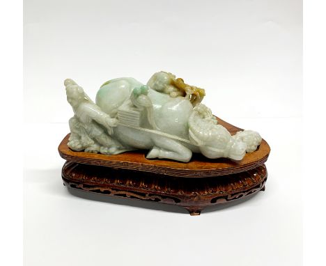 A superb carved Chinese jade figure of two boys with a water buffalo on a purpose made wooden stand, L. 27cm, H. 15cm.