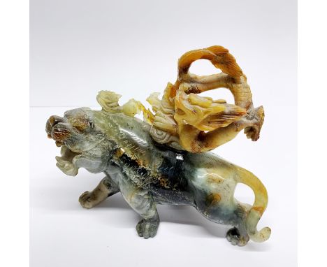 A large Chinese carved jade/hardstone figure of a tiger with a dragon on his back, H. 16cm.