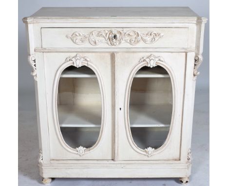 A VICTORIAN STYLE WHITE PAINTED OAK SIDE CUPBOARDSingle drawer over oval glass doors on turned supports 96cm wide; 104cm high