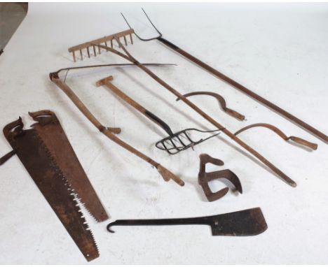 A QUANTITY OF LATE 19TH CENTURY FARMING TOOLSTo include a butchers cleaver, pitch fork, rakes, a scythe and sundry