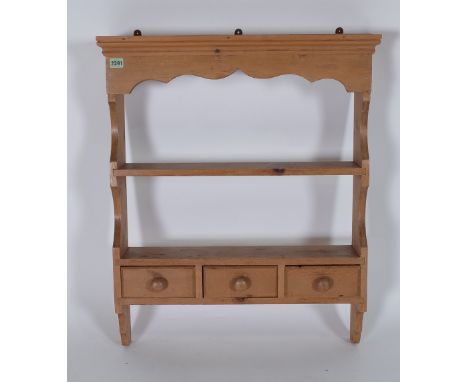 A MODERN PINE HANGING SHELFWith three frieze drawers 66cm wide; 81cm high