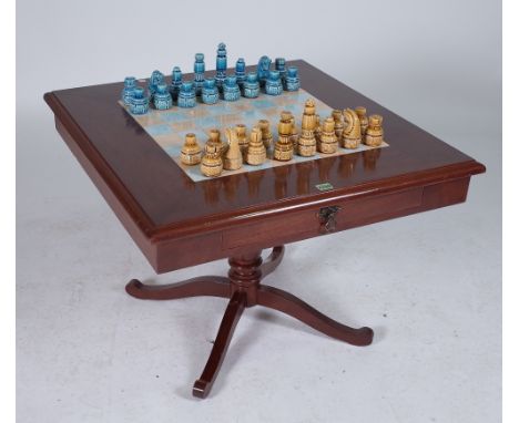 A MODERN STAINED BEECH AND INSET TILED TOP CHESS TABLEWith ceramic gaming pieces 78cm wide; 52cm high