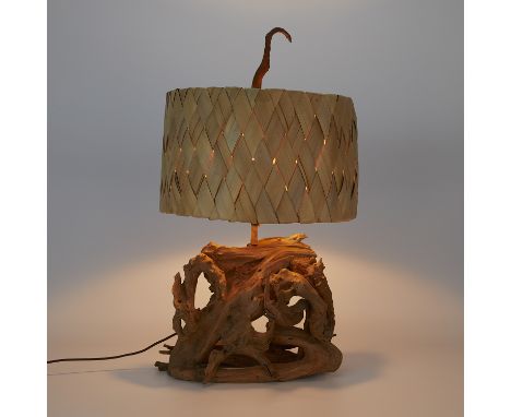 Mid-century modern driftwood table lamp with a woven palm leaf lampshade.Height: 27 in x width: 14 in x depth: 15 1/2 in.Cond