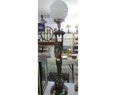 A 20th century bronzed lady table lamp with outstretched arms holding globe