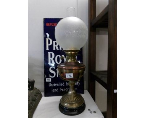 An oil lamp with brass base, copper font and etched shade