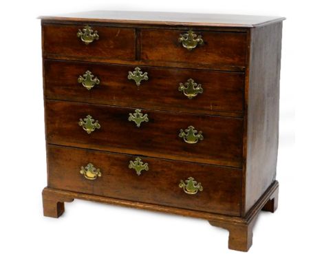 An early 19thC oak chest of drawers, the top with a moulded edge above two short and three long drawers, each with brass hand