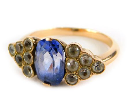 An Art Deco style ring, with oval cut pale blue sapphire, flanked by triangle staggered design set with six white sapphires, 