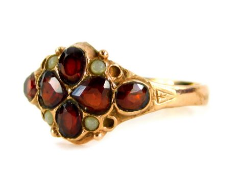 A 9ct gold garnet dress ring, the central four leaf clover design garnet with four moonstone borders and two oval cut amethys