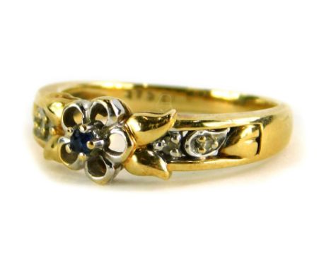 A 9ct gold dress ring, with central floral design set with single sapphire, in a silvered colour petal leaf, with diamond set