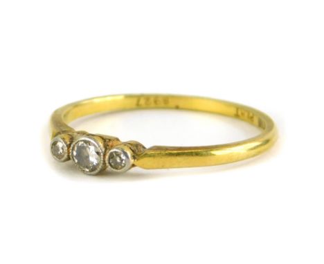 A late Victorian dress ring, set with three tiny diamonds, each in platinum illusion setting, on a yellow metal band stamped 