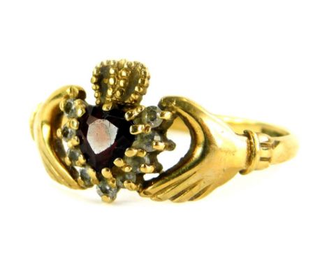 A 9ct gold Claddagh dress ring, with heart shaped central garnet stones, surrounded by white stones with a gold crown, ring s