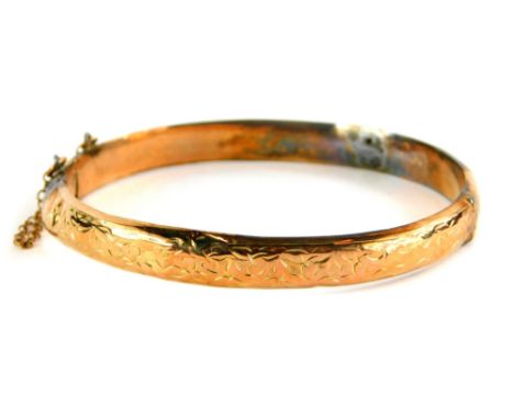A 9ct gold hinged bangle, the hammered decoration upper tier on single clasp with safety chain, 6cm diameter, 8.5g all in. (A