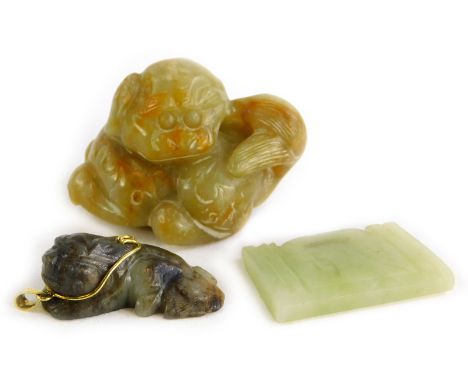 Three various oriental carvings, to include a soapstone figure of a seated lion, in a gold plated pendant frame, a soapstone 