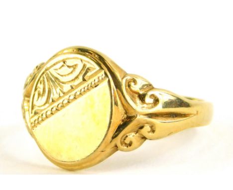 A 9ct gold signet ring, the oval shield with partial engraved decoration, on two splay scroll shoulders, with import marks, r