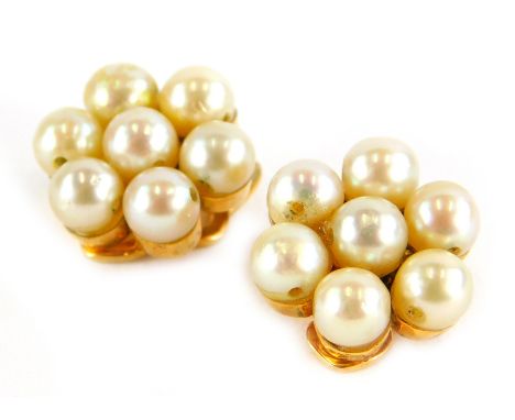 A pair of pearl earrings, each in a cluster group, with seven pearls, in a yellow clip on metal frame, unmarked, 3.7g all in.