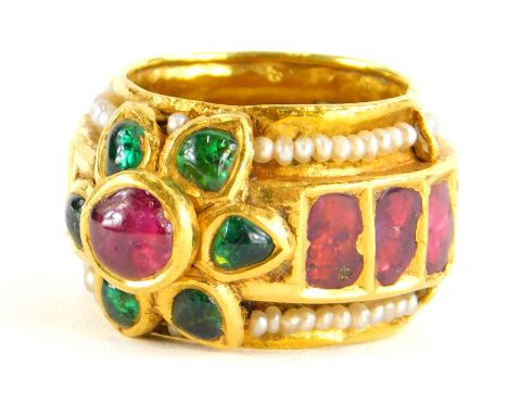 An Indian dress ring, set with various cabochon cut rubies, emeralds and seed pearls, the centre cluster in raised setting, t