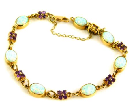 An amethyst and opal bracelet, set with a group of oval opals, and four point amethyst clusters, on a yellow metal band, stam