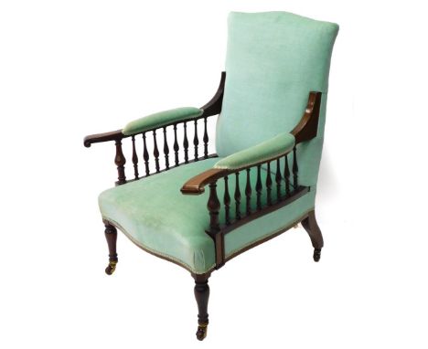 A late 19th/early 20thC mahogany armchair, upholstered in turquoise fabric with shaped arms, each with turned supports, on tu