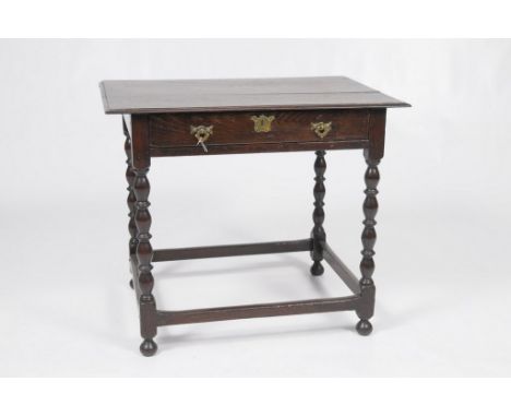 An 18th Century oak side table
The rectangular moulded three plank top above a frieze drawer engraved brass escutcheon later 