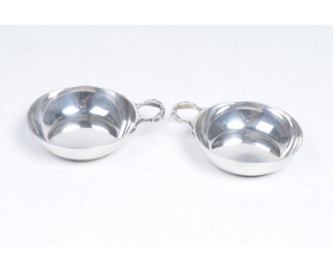 A pair of Elizabeth II silver wine tasters
Each of plain circular form, flanked by crane form loop handle, Tessiers Ltd (Herb