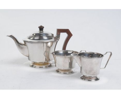 A George VI silver three-piece tea service
Comprising teapot with wooden handle and finial, twin handled sucrier and milk jug