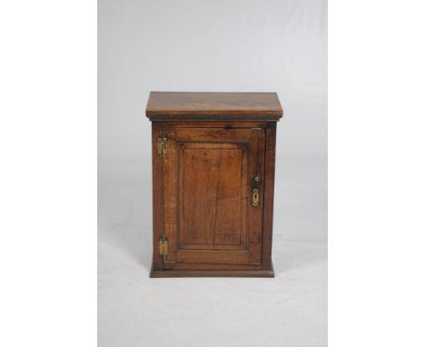 An 18th Century oak hanging spice cupboard
The later rectangular top above a panelled cupboard door, H-brass hinges and origi