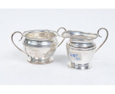 A George V silver sugar bowl and milk jug
Each of plain form raised on a short pedestal foot with high loop handle, milk jug,