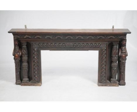 A 17th Century and later oak fire surround, reduced
The rectangular shelf above an interlaced scrolling frieze carved with ov