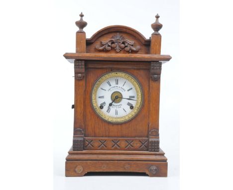 A Victorian oak mantle clock
With a 11.5cm white dial signed Fattorini & Sons, Bradford, patent automatic alarm with a two tr