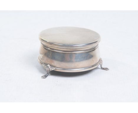 A silver bound lidded pin cushion
Of rounded form, raised on three swept paw supports, the engine turned hinged cover reveali